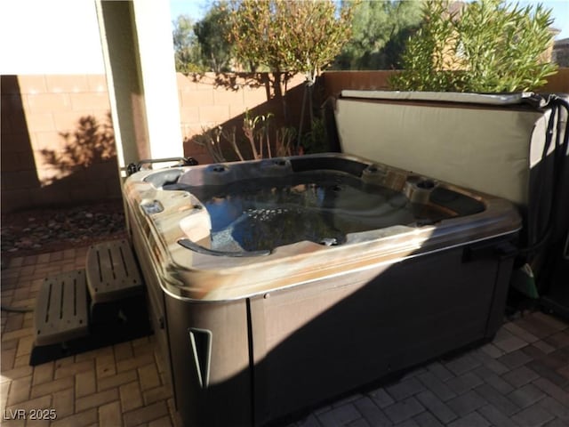 view of patio featuring a hot tub and fence