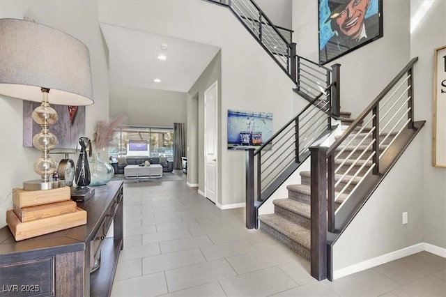 entryway with stairway, a high ceiling, baseboards, and recessed lighting