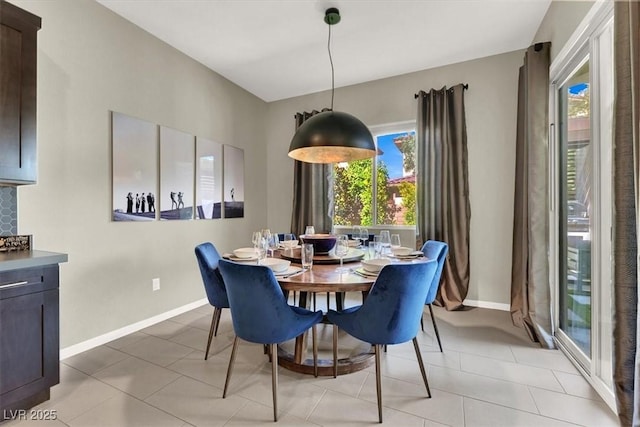 dining space with baseboards and light tile patterned floors