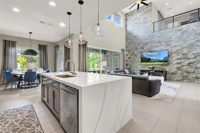 kitchen with a center island with sink, visible vents, open floor plan, stainless steel dishwasher, and a sink