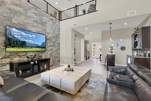 living room with visible vents, a towering ceiling, and baseboards