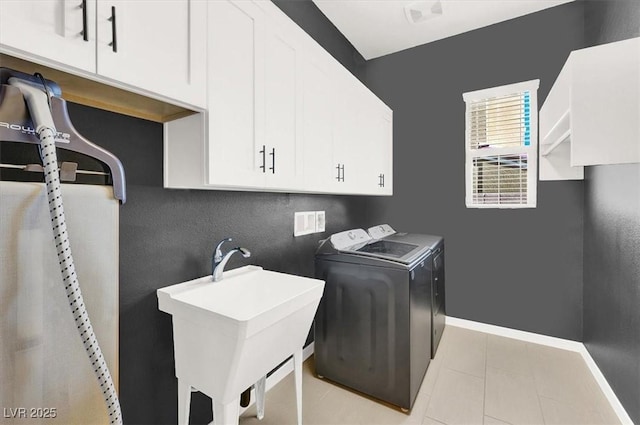 laundry room with baseboards, a sink, cabinet space, and washer and dryer