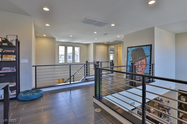 hallway featuring visible vents, an upstairs landing, and recessed lighting