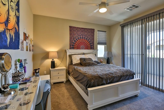 bedroom with visible vents, dark colored carpet, and a ceiling fan