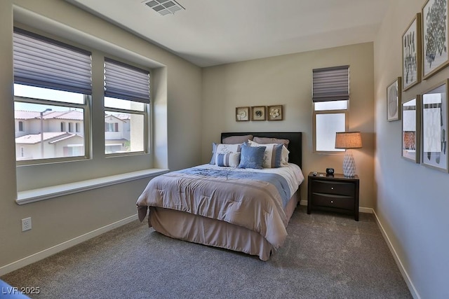 bedroom featuring dark colored carpet, visible vents, and baseboards