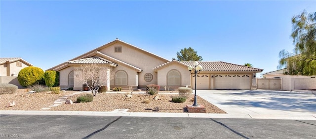 mediterranean / spanish house featuring driveway, a tiled roof, a garage, and stucco siding