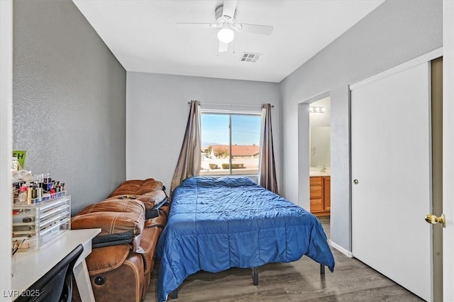 bedroom featuring ceiling fan, visible vents, wood finished floors, and ensuite bathroom