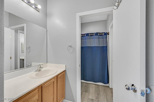 bathroom featuring wood finished floors, vanity, and a shower with curtain