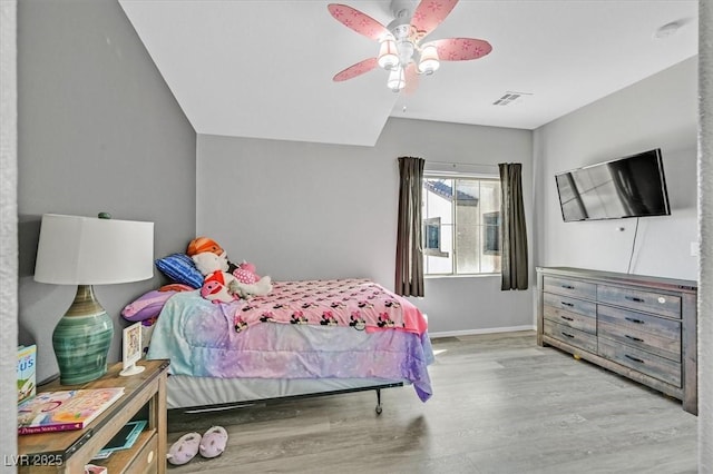 bedroom featuring visible vents, baseboards, light wood-style flooring, and a ceiling fan