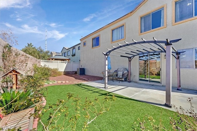 rear view of house with a yard, stucco siding, central AC unit, a pergola, and a fenced backyard