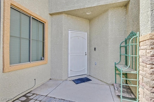 doorway to property featuring a patio and stucco siding