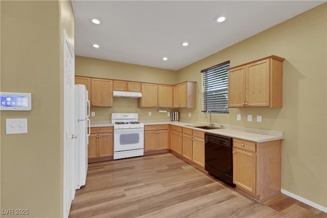 kitchen featuring white appliances, light countertops, under cabinet range hood, light brown cabinets, and a sink