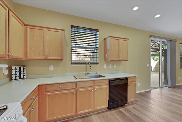 kitchen featuring black dishwasher, stove, light countertops, light brown cabinetry, and a sink