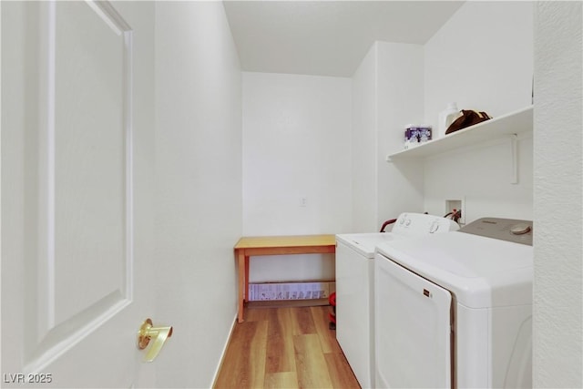 laundry area with laundry area, light wood finished floors, and washer and dryer