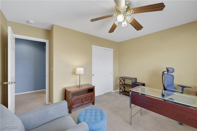 office area featuring ceiling fan, baseboards, and light colored carpet