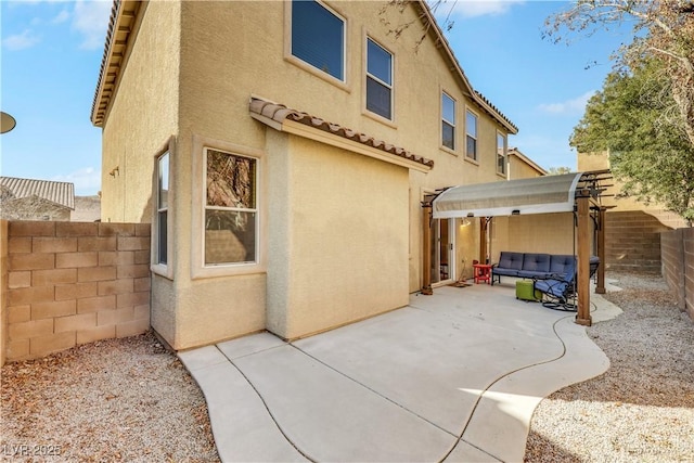 back of property featuring a patio area, a fenced backyard, an outdoor hangout area, and stucco siding