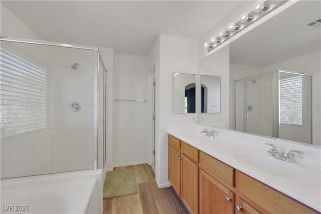 full bathroom featuring visible vents, a sink, a shower stall, and wood finished floors