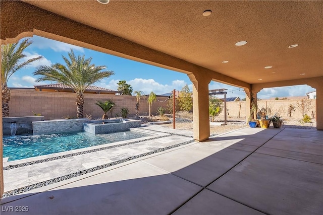 view of patio / terrace with a fenced backyard and an in ground hot tub