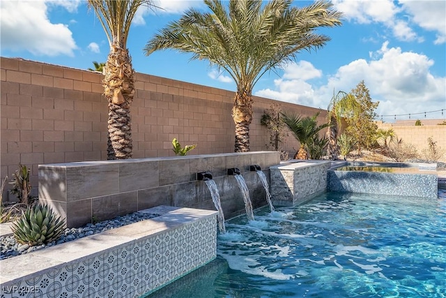 view of swimming pool with a fenced backyard and a jacuzzi