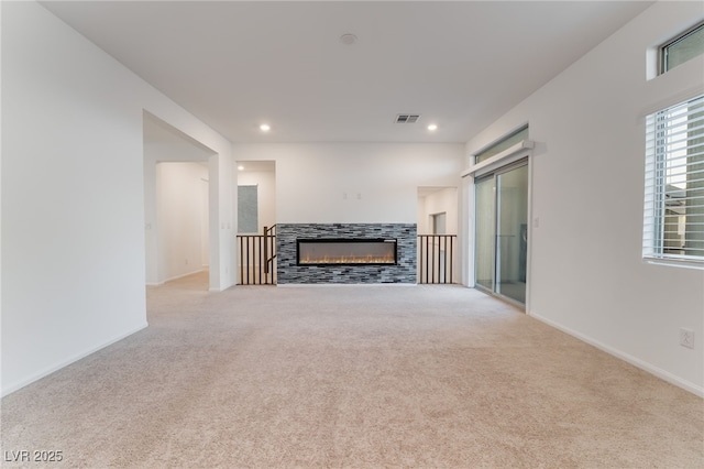 living area featuring a tile fireplace, light carpet, baseboards, and recessed lighting