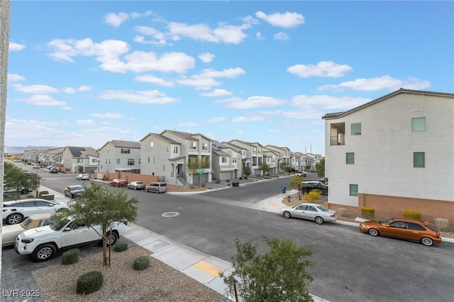 view of street with curbs, sidewalks, and a residential view