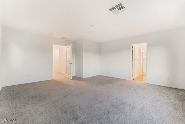 unfurnished room featuring visible vents and light colored carpet