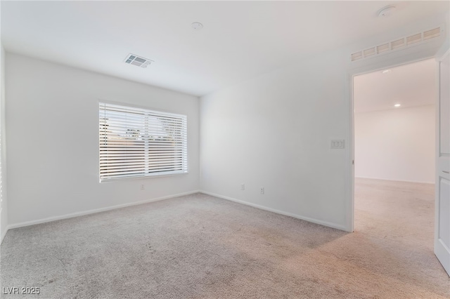 empty room with light carpet, visible vents, and baseboards