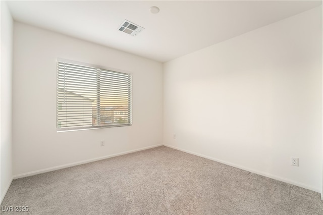 carpeted empty room featuring baseboards and visible vents