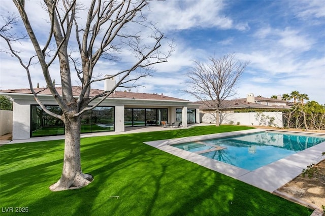 view of pool with a patio area, a pool with connected hot tub, fence, and a yard