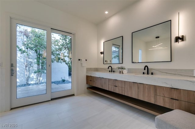 bathroom featuring double vanity, a sink, and recessed lighting