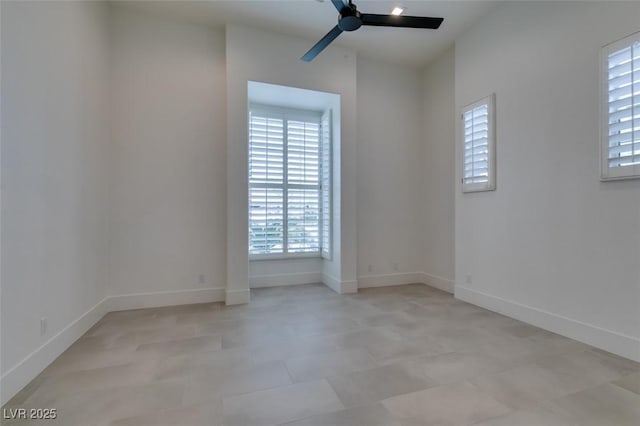 unfurnished room featuring ceiling fan and baseboards