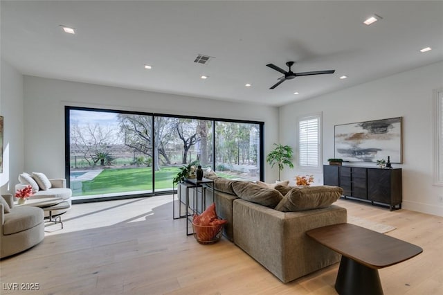 living area featuring baseboards, light wood-style flooring, visible vents, and recessed lighting