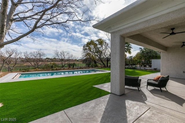 view of yard featuring a fenced in pool, a fenced backyard, a patio, and ceiling fan