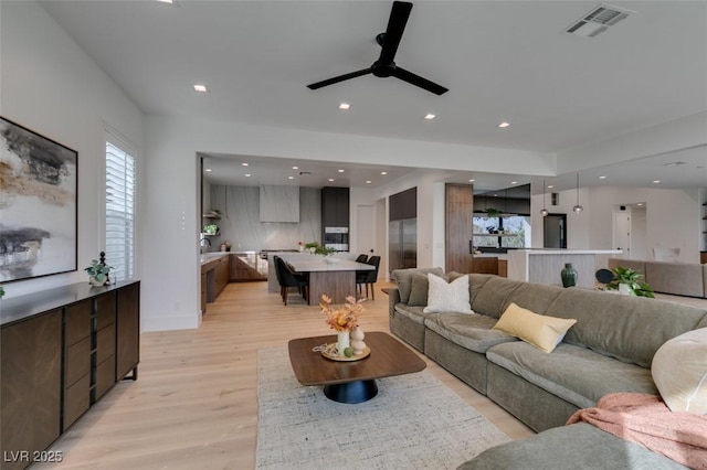 living area featuring light wood-style floors, visible vents, a ceiling fan, and recessed lighting