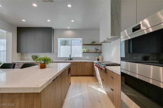 kitchen featuring plenty of natural light, light countertops, stainless steel gas cooktop, and modern cabinets