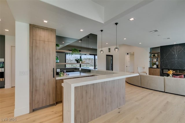 kitchen with visible vents, open floor plan, light countertops, light wood finished floors, and modern cabinets