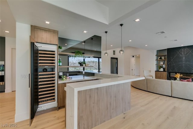 kitchen with beverage cooler, visible vents, light wood-style floors, open floor plan, and modern cabinets