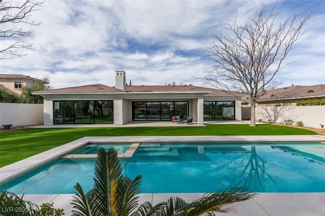 view of pool with a fenced backyard, a pool with connected hot tub, a lawn, and a patio