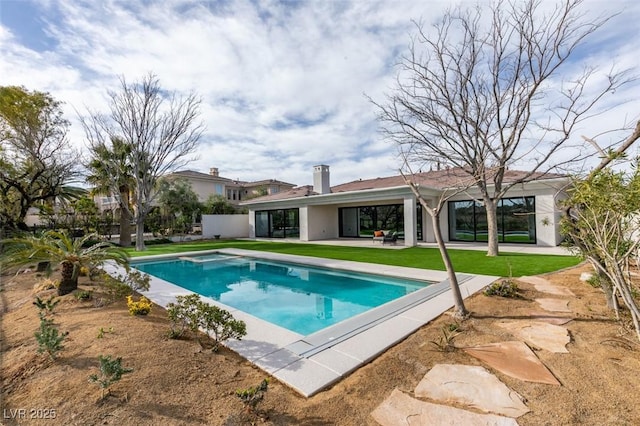 view of pool with a lawn and a patio