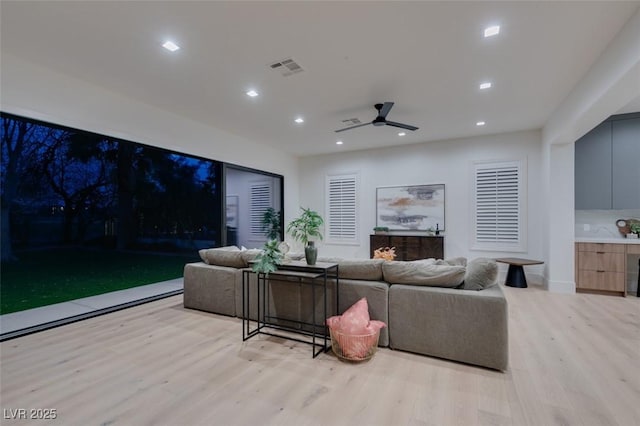 living room with a ceiling fan, recessed lighting, visible vents, and light wood-style flooring