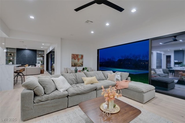 living area with recessed lighting, visible vents, a ceiling fan, and wood finished floors