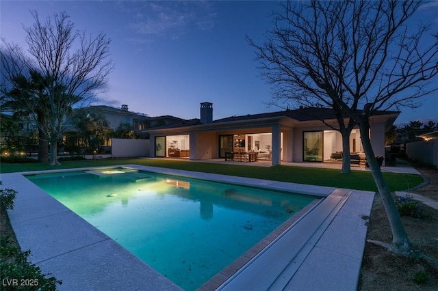 outdoor pool featuring a patio area and a lawn