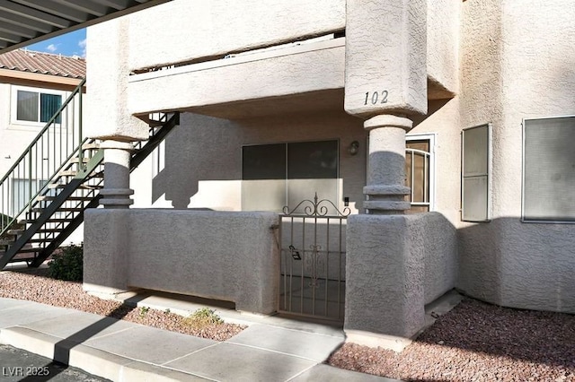 exterior space featuring a gate and stucco siding