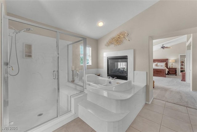 ensuite bathroom featuring lofted ceiling, a stall shower, ensuite bath, and tile patterned floors