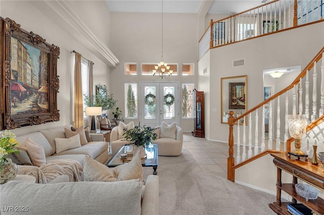 living room featuring a notable chandelier, a towering ceiling, stairway, tile patterned flooring, and baseboards