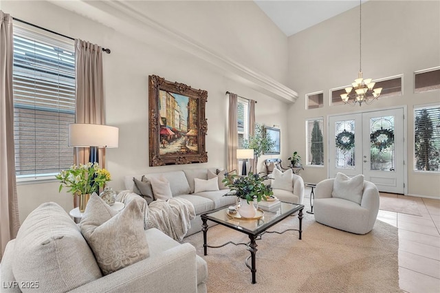 living area with french doors, light tile patterned flooring, a high ceiling, and an inviting chandelier