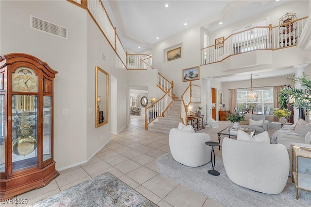 entryway with light tile patterned flooring, visible vents, decorative columns, and stairs