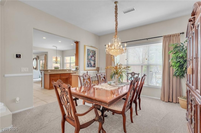 dining room with light carpet, a healthy amount of sunlight, baseboards, and visible vents