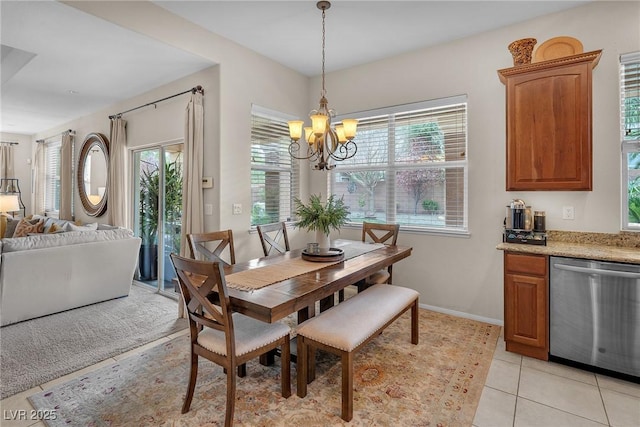 dining space with baseboards, a chandelier, and light tile patterned flooring