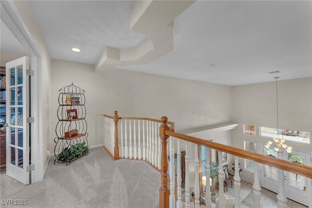 hallway featuring baseboards, carpet, an upstairs landing, a notable chandelier, and recessed lighting